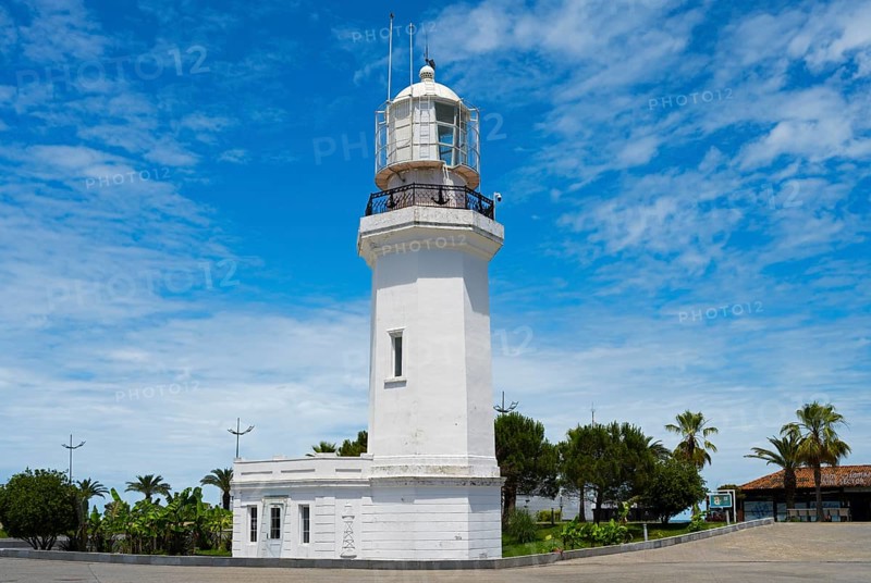 White lighthouse against a blue sky with some clouds surrounded by palm trees and vegetation, lighthouse, Batumi, Black Sea, Ajara region, Adjara, autonomous republic, Georgia