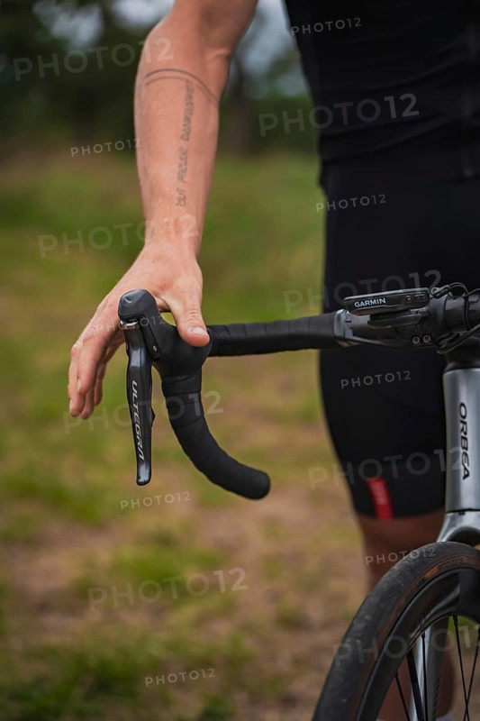 Close-up of a hand on the handlebars of a racing bike with visible tattoo, triathlon, Calw, Germany