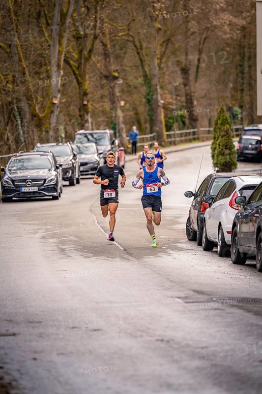 Two runners on a wooded village road with parked cars, triathlon, Calw, Germany