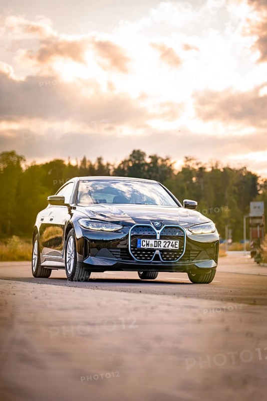 Black car on the road in natural setting at sunset, BMW i7 electric car, Deer E- Carsharing, Calw, Germany