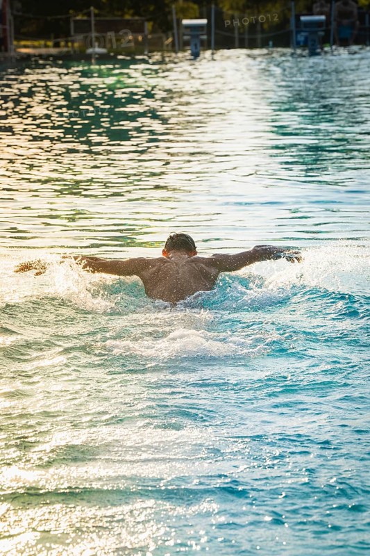 A swimmer swims in the pool, the afternoon sun reflecting on the water, Triathlon, Calw, Germany