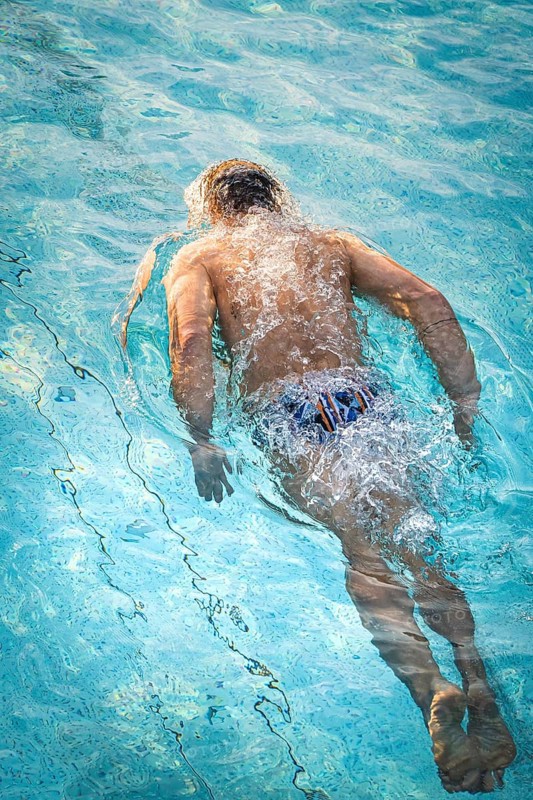 A swimmer dives through the pool and creates dynamic water splashes, Triathlon, Calw, Germany