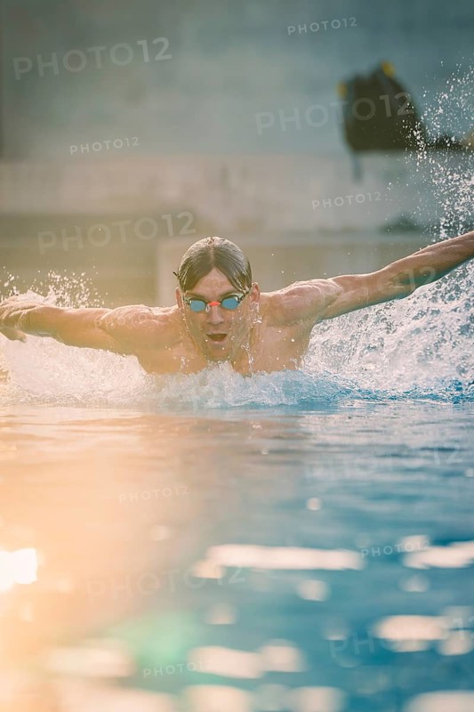 A swimmer wearing sunglasses in the pool shows a powerful swimming movement, Triathlon, Calw, Germany