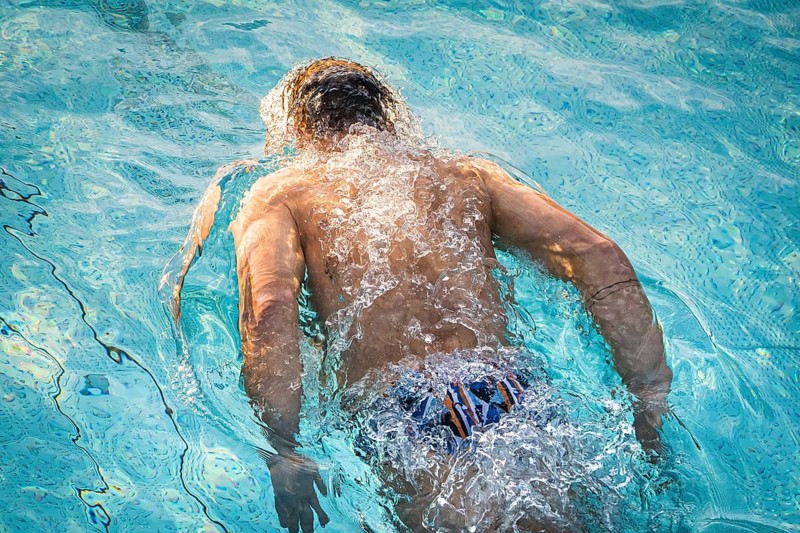 A swimmer in the pool shows energetic movements with strong splashes of water, Triathlon, Calw, Germany