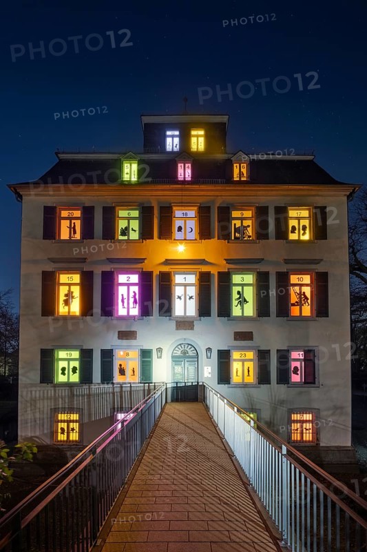 The windows of the Holzhausenschlösschen in Holzhausenpark in Frankfurt am Main shine brightly in December as Frankfurt's largest advent calendar. Each window shows an individual motif as a shadow cut, Holzhausenpark, Frankfurt am Main, Hesse, Germany