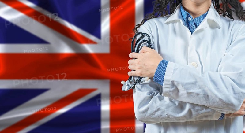 Healthcare professional with United Kingdom flag background. Professional doctor holding stethoscope on United Kingdom flag background