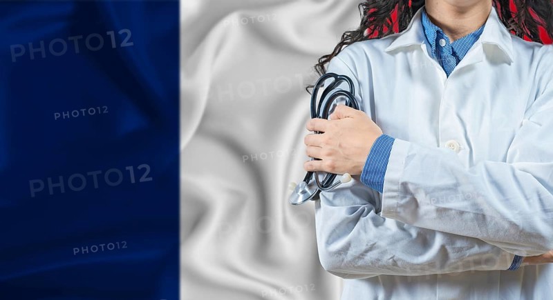 Healthcare professional with France flag background. Professional doctor holding stethoscope on France flag background