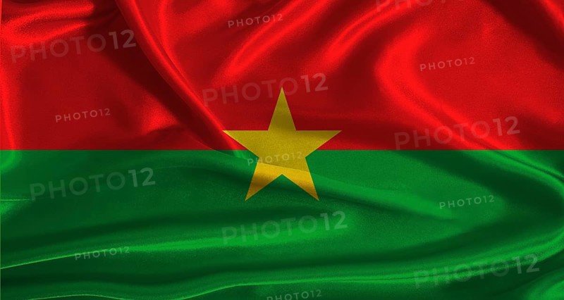 Burkina Faso flag with cloth textured background. National flag of Burkina Faso with realistic texture