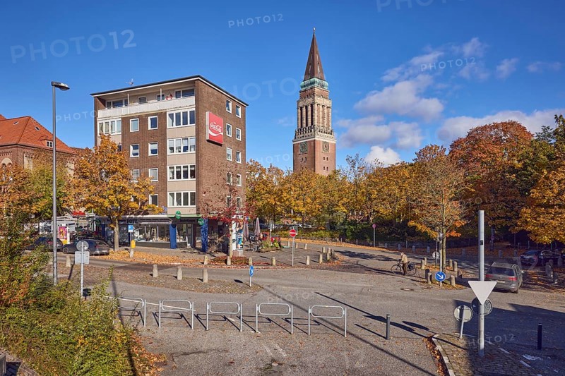 Residential and commercial buildings, brick buildings, brick architecture, general architecture, town hall tower, advertising drink Coca-Cola, barrier, central island, lantern, trees, autumn leaves, cyclists as a secondary motif, blue sky, cumulus clouds, roads intersection Kleiner Kuhberg with Waisenhofstraße, Kiel, state capital, district-free city, Schleswig-Holstein, Germany