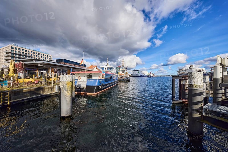 Kiel Fjord, harbor, duckdalben, quay, passenger ship, tugboat, ferry ship, ships, general architecture, outdoor area of a restaurant, bar and café Blauer Engel, water surface with small waves, blue sky, cumulus clouds, stratocumulus clouds, white and dark clouds, Kiel, state capital, district-free city, Schleswig-Holstein, Germany