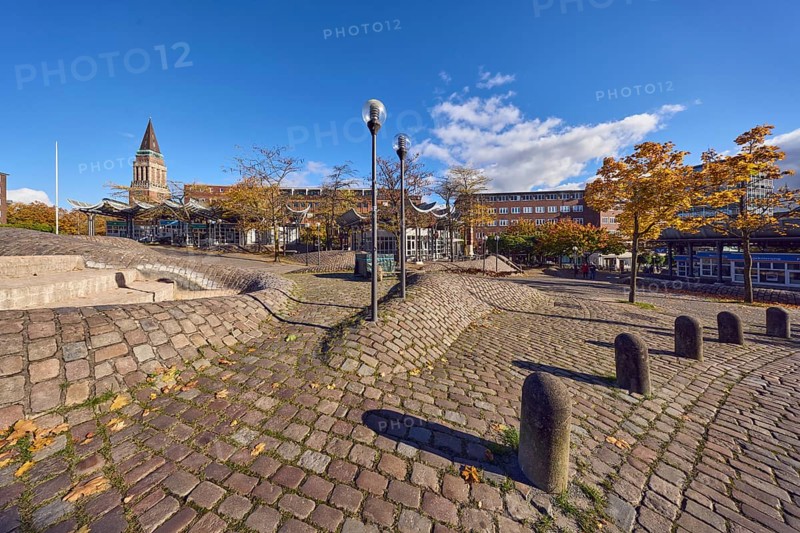 Pedestrian zone, lantern, barrier bollard, cobblestone walkway, general architecture, brick buildings, brick architecture, town hall tower, fountain, trees, autumn leaves, blue sky, cumulus clouds, Europaplatz, Kiel, state capital, district-free city, Schleswig-Holstein, Germany