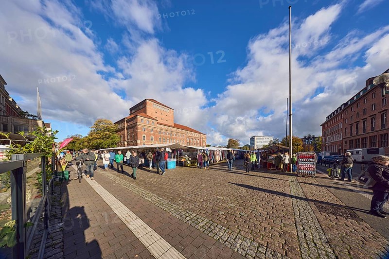 Opera house, general architecture, historic brick building, brick architecture, square, flagpoles, market stalls, market visitors and pedestrians as accessories, sidewalk made of concrete paving stones, cobblestones and paving stones, blue sky, cumulus clouds, town hall square, Kiel, state capital, district-free city, Schleswig-Holstein, Germany