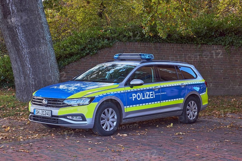 Police car, Volkswagen, VW, brick wall, tree, meadow, sunny, Kiel, state capital, district-free city, Schleswig-Holstein, Germany