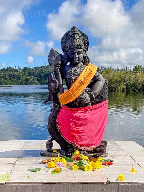 Statue sculpture of war deity Muruga, son of Shiva and Parvati, also worshipped as god of Tamil Kadavul, symbolizes courage wisdom and victory over evil, stands in holy Hindu lake Ganga Talao at religious site largest Hindu shrine for religion Hinduism outside India for believers Hindu Hindus, in the background Sacred Lake Ganga Talao crater lake in crater of extinct volcano, Grand Bassin, Le Pétrin, Mauritius