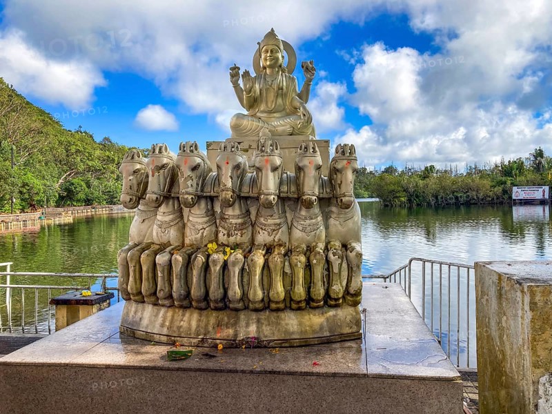 Sculpture statue of sun god Suraya in wagon is pulled from in front of seven 7 horses stands in behind in the background crater lake in crater of extinct volcano sacred Hindu lake Ganga Talao at religious site largest Hindu sanctuary for religion Hinduism outside India for believers Hindu Hindus, Grand Bassin, Le Pétrin, Mauritius