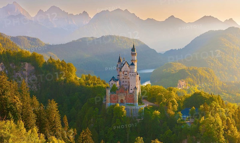 Neuschwanstein Castle in the midst of a fairytale alpine panorama during sunrise surrounded by forests, Schwangau near Füssen, Ostallgäu, Allgäu, Bavaria, Germany