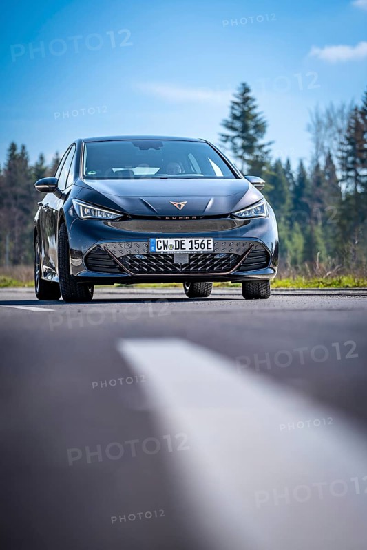 Modern black car on a country road in front of a forest under a blue sky, electric car Cupra, e-car sharing, Calw, Germany