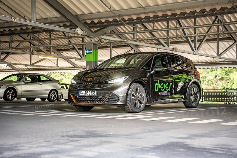 A dark car is parked under a roof in a modern parking garage, electric car Cupra, e-car sharing, Calw, Germany