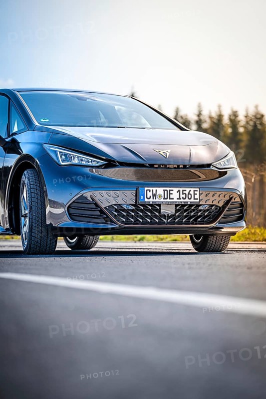 Close-up black car on a road with forest in the background, electric car Cupra, e-car sharing, Calw, Germany