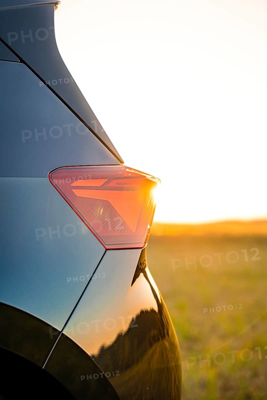 Close-up of a car light at sunset with golden evening mood in the background, electric car Cupra, e-car sharing, Calw, Germany