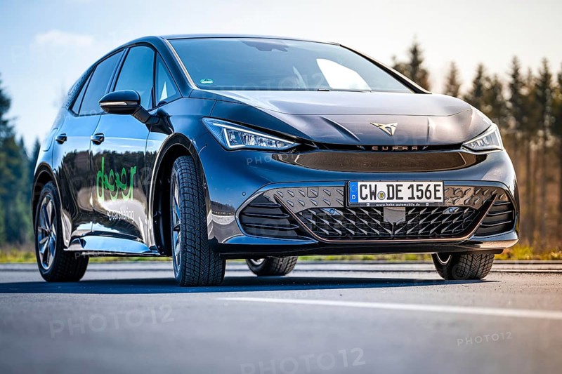 Black car on a road with forest in the background under clear sky, electric car Cupra, e-car sharing, Calw, Germany