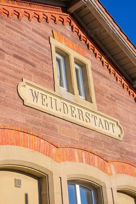 Brick building with Weilderstadt lettering under blue sky, Weil der Stadt railway station, Germany