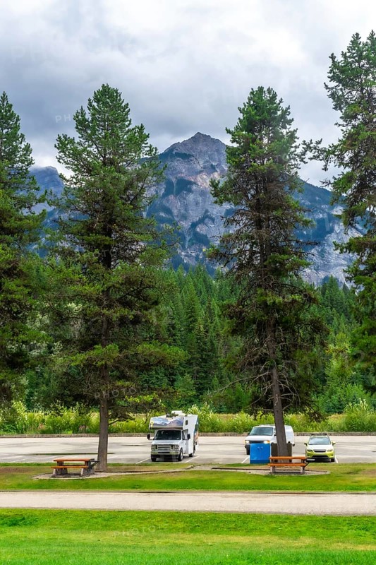 Recreational vehicles and cars parked in a campground near majestic mount robson, the highest peak in the canadian rockies, offering breathtaking views in british columbia