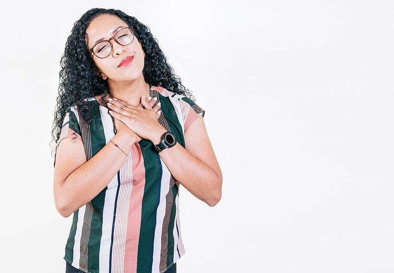 Positive afro woman with lovely sincere smile feeling thankful, relaxed afro girl showing thank you gesture with hands on chest, Grateful people concept