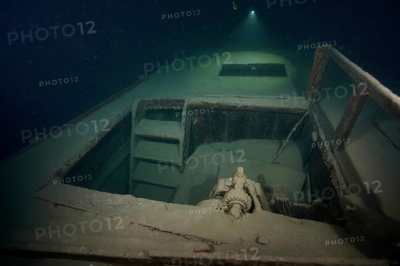 Diver examines a lediwreck, wreck of a lediship, ledi ship, cargo ship for mass freight, bulk cargo, at night in Lake Walen. Tauchplatz Känzeli, Mols, Canton of St. Gallen, Switzerland