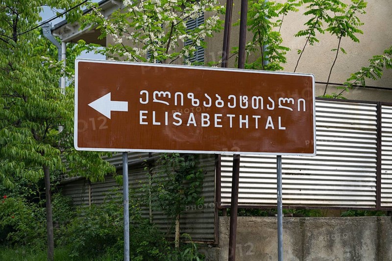 Brown road sign points towards Elisabeththal in Georgian and English letters, village founded by Caucasian Germans, Asureti, Asureti, Elizabeth Valley, Lower Kartli region, Georgia