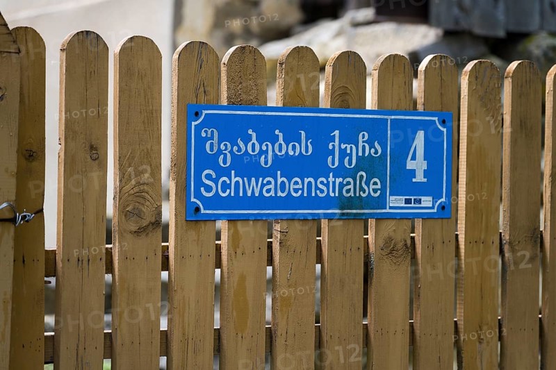 Blue street sign with house number 4 on a wooden fence in Georgian and German letters, Schwabenstraße, village founded by Caucasian Germans, Asureti, Asureti, Elizabeth Valley, Lower Kartli region, Georgia