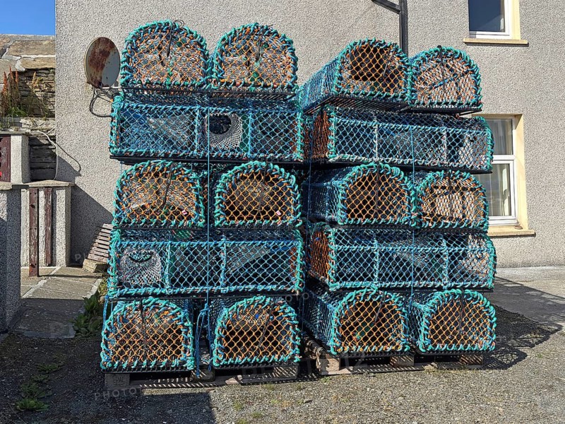 Stacked fishing baskets outside a building ready for fishing, Westray, Orkney Islands, Scotland, Great Britain