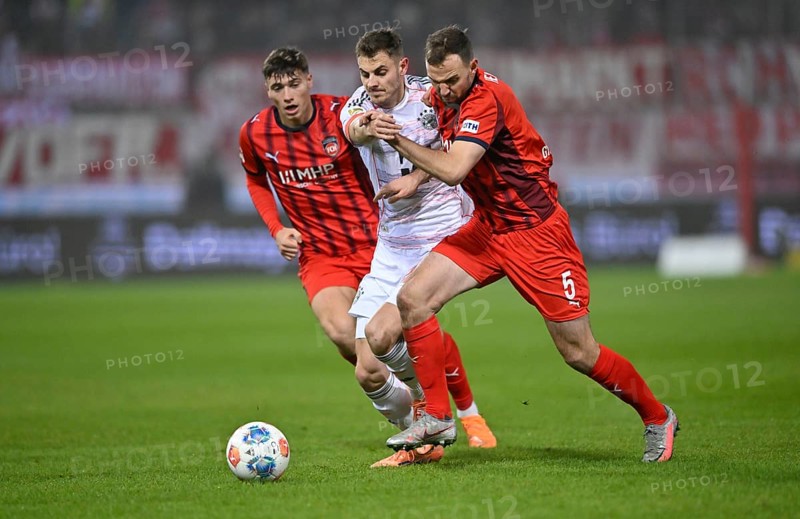 One-on-one, action Josip Stanisic FC Bayern Munich FCB (44) (centre) against Benedikt Gimber 1. FC Heidenheim 1846 FCH (05) Luca Kerber 1. FC Heidenheim 1846 FCH (20) Voith-Arena, Heidenheim, Baden-Württemberg, Germany