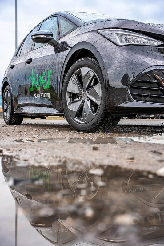 Car with reflection in a wet puddle on a street, Deer E-Car Sharing, Cupra electric car, Germany