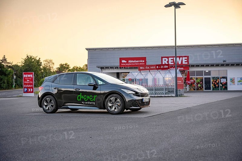 Car parked in a parking lot in front of a supermarket in the evening light, Deer e-car sharing, Cupra electric car, Germany