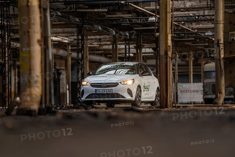 A white car with car sharing logo is parked in an old industrial building, Deer E-Car Sharing, Motorworld Rüsselsheim, Germany