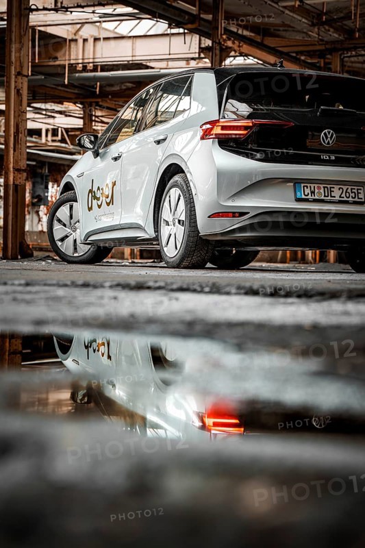 The vehicle is reflected in a puddle on the floor of an abandoned factory, Deer E-Car Sharing, Motorworld Rüsselsheim, Germany