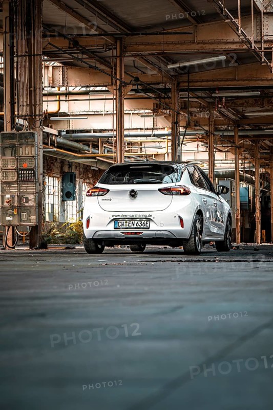 White vehicle in a large, empty industrial building, urban feel, Deer E-Car Sharing, Motorworld Rüsselsheim, Germany