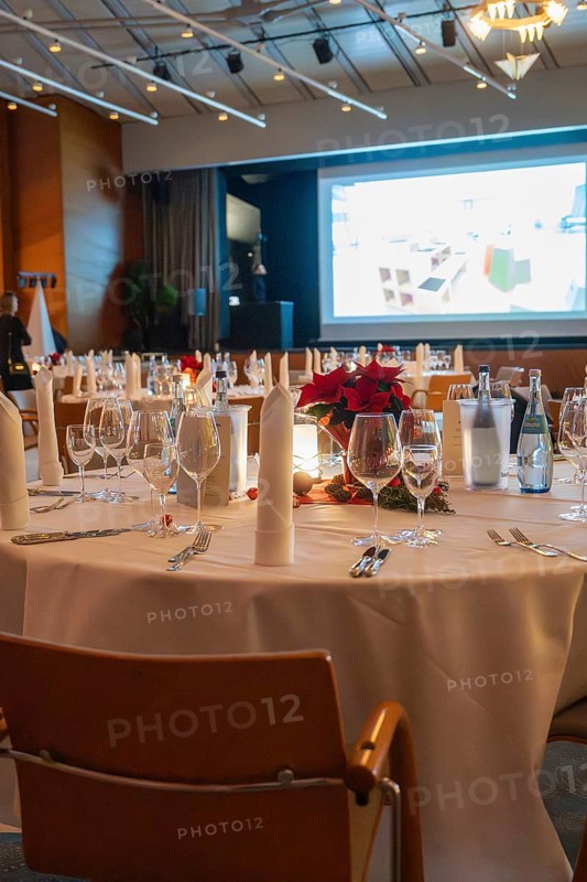 An elegant banquet hall with festively decorated tables and a projection screen in the background, Dekra Congresshotel Wart Christmas party, Calw district, Germany