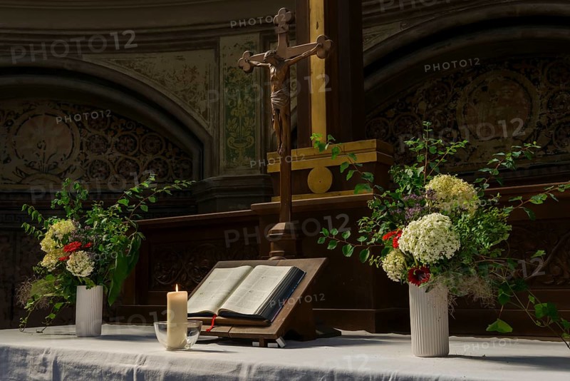 Decorated church altar with Jesus cross and Bible with burning candle