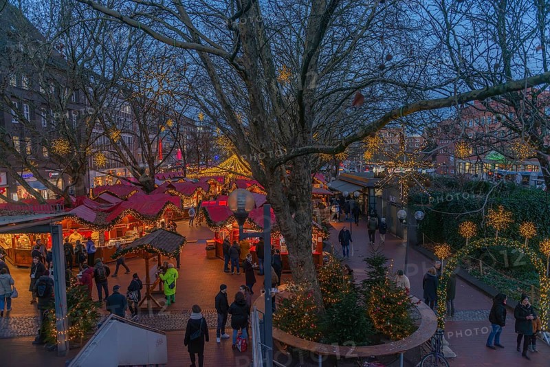Christmas market on Holstenplatz in Kiel, city center, trees, shops, pedestrian zone, early evening, stalls, visitors, glowing stars, lights, Christmas decorations, fun, festive atmosphere, Christian festival, view from above, Schleswig-Holstein, Germany