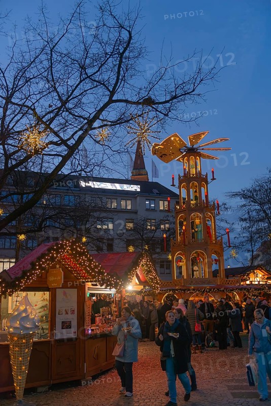 Christmas market at Ausmus-Bremer-Platz in Kiel, pedestrian zone, early evening, stalls, visitors, glowing stars, lights, Christmas decorations, Christmas pyramid, fun, festive atmosphere, Christian festival, Schleswig-Holstein, Germany