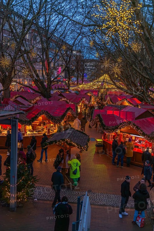 Christmas market on Holstenplatz in Kiel, city center, trees, shops, pedestrian zone, early evening, stalls, visitors, glowing stars, lights, Christmas decorations, fun, festive atmosphere, Christian festival, view from above, Schleswig-Holstein, Germany
