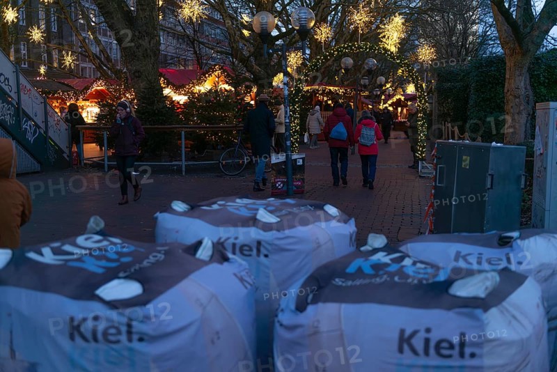 Safety measures for the Christmas market on Holstenplatz in Kiel, city center, Christian festival, lettering, barrier, sandbags, barriers, protection, fear, danger, evening, glowing stars, booths, trees, pedestrian zone, Christmas decorations, visitors, Schleswig-Holstein, Germany