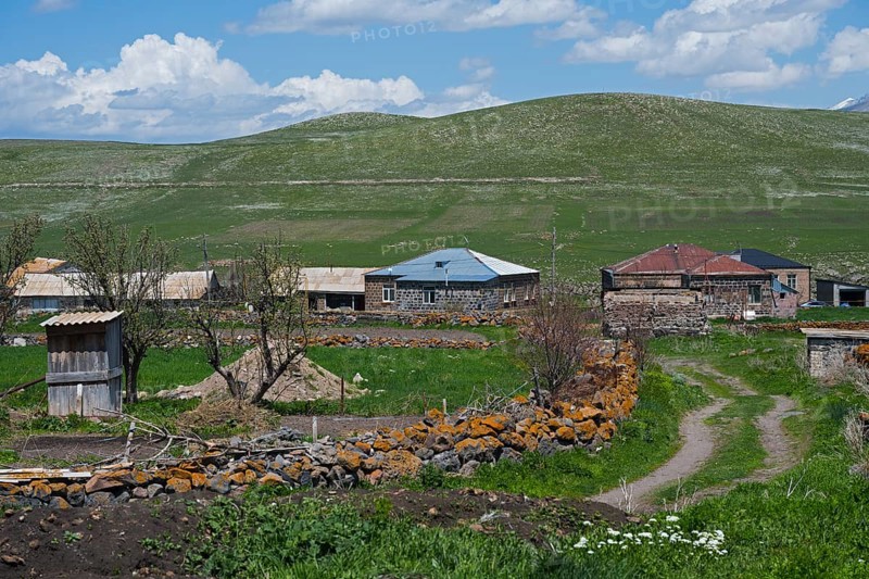 Quiet rural village with stone houses and green fields under blue sky, Jigrasheni, Samtskhe—Javakheti region, Samtske Javacheti, Lesser Caucasus, Georgia