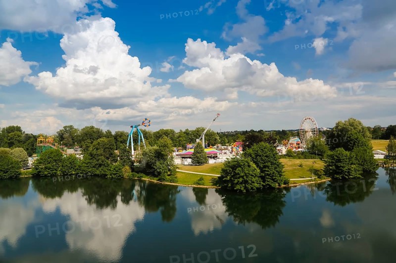Fairground in Ulm Friedrichsau at night, folk festival, hustle and bustle, fair, amusement park, amusement attraction, ride, blue sky, clouds, natural lake, Ausee, artistico the largest transportable swing in the world, no limit carousel, Ferris wheel, Ulm, Baden-Württemberg, Germany