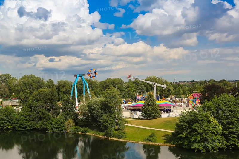 Fairground in Ulm Friedrichsau, folk festival, hustle and bustle, amusement park, amusement attraction, ride, blue sky, clouds, natural lake, Ausee, artistico the largest transportable swing in the world, Ulm, Baden-Württemberg, Germany