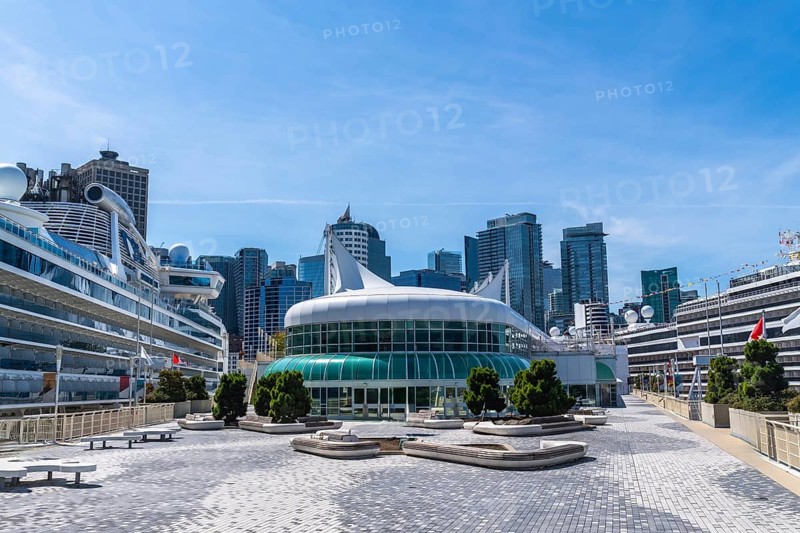 Canada place, a prominent landmark and cruise ship terminal in vancouver, british columbia, stands tall against a backdrop of modern skyscrapers, welcoming tourists on a sunny day