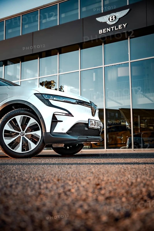 Car in front of a Bentley logo building, modern design and glass façade, Deer e-car sharing, Renault Megane, Calw, Germany