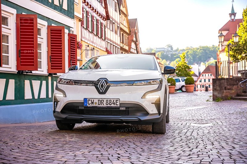 White car on cobblestone road in front of traditional half-timbered houses in sunshine, Deer E-Carsharing, Renault Megane, Calw, Germany